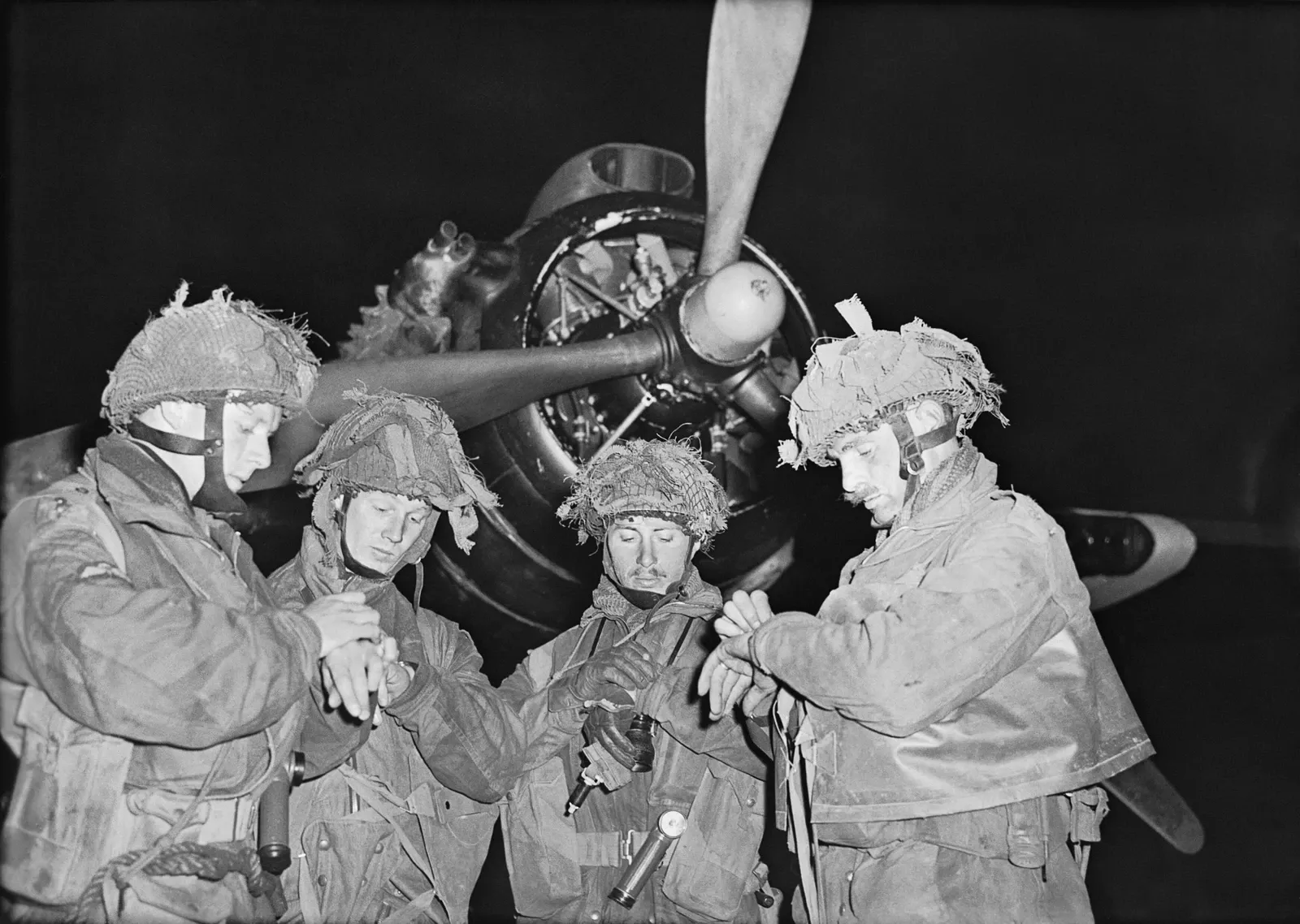 Négy brit ejtőernyős tiszt órát egyeztet egy Albemarle előtt a harwelli repülőtéren, 1944. június 5-én