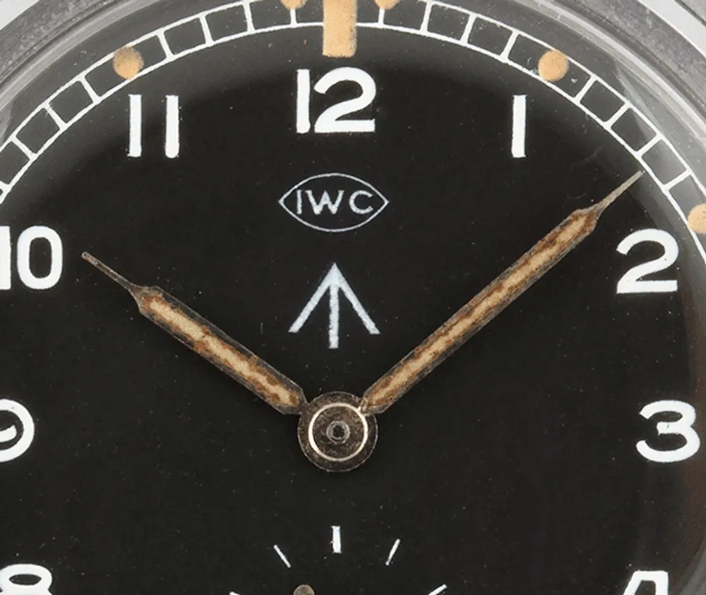 Az IWC W.W.W. számlaprészlete, a gyártói logó alatt a brit broad arrow tulajdonjellel