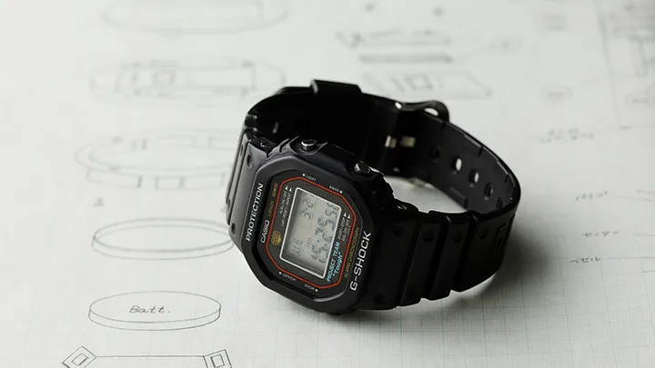 A klasszikus négyzetes G-Shock egy korai műszaki rajz fölött
