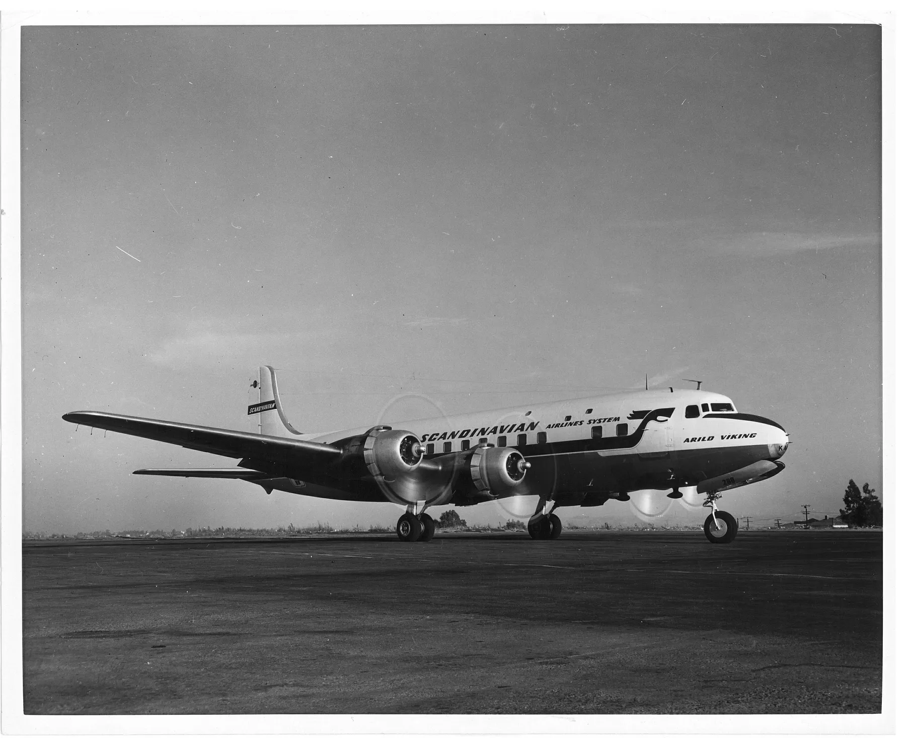 A SAS négymotoros Douglas DC-6B repülőgépe korabeli fekete-fehér felvételen, a földön.