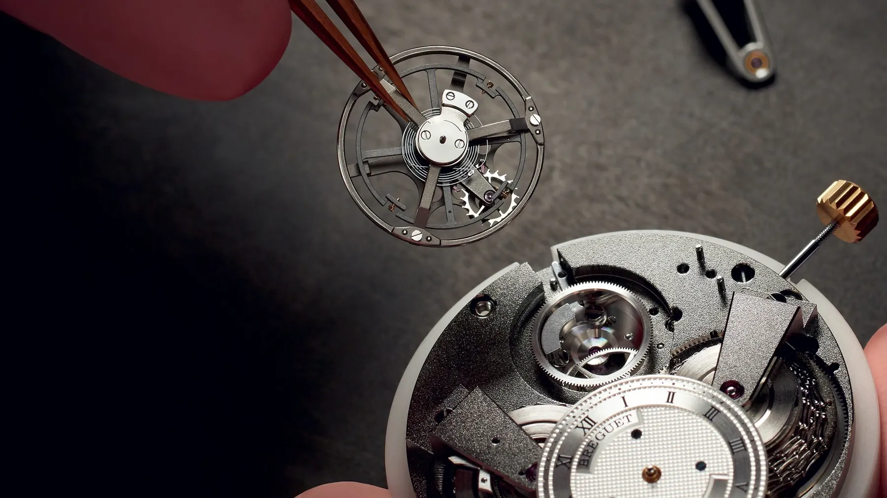 Órás csipesszel emeli a Breguet Tradition tourbillon-egységét a szerkezet fölé, műhelymunka közben.
