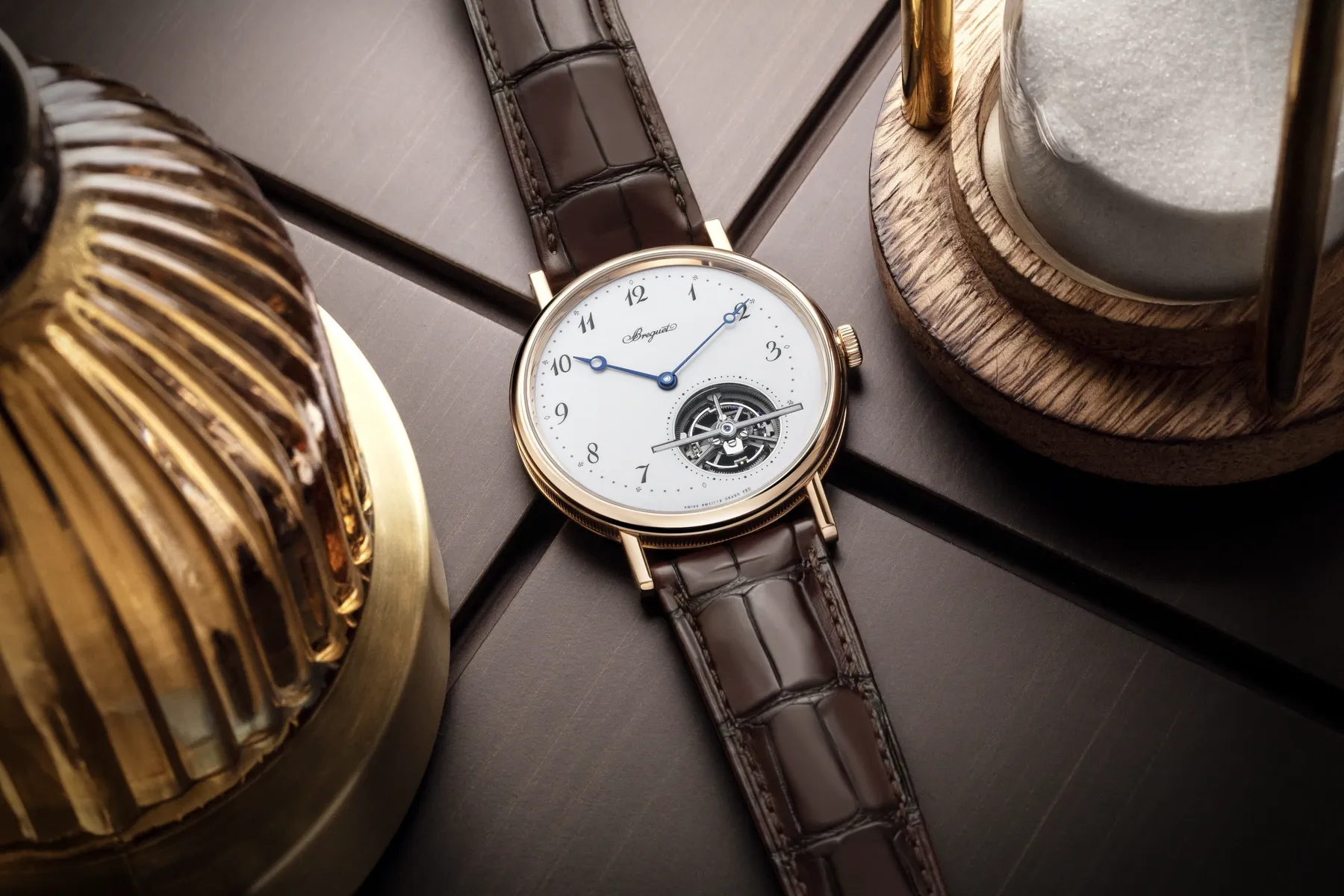 Breguet Classique 5367 valódi tárgyfotón, a zománcszámlappal és a tourbillon nyílásával, műhelytárgyak között.