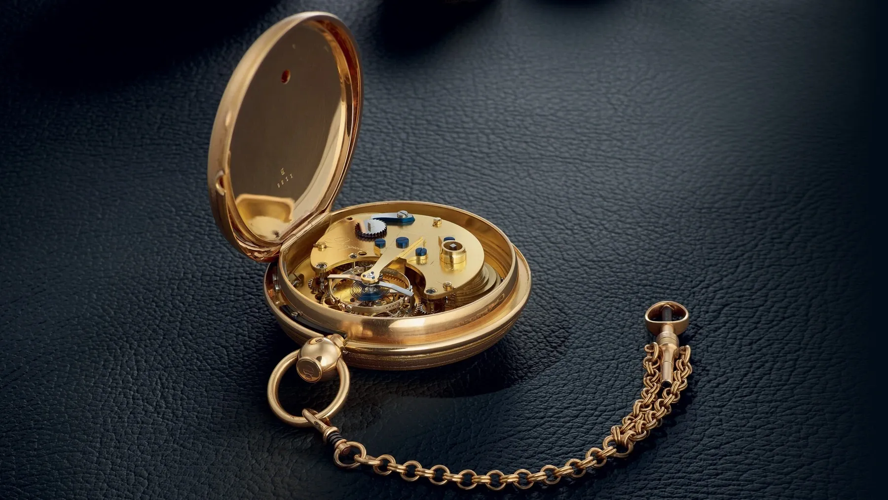 A történeti Breguet 1188-as zsebóra nyitott hátlappal, a láncával és a látható szerkezetével.